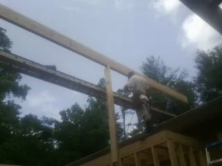 Carpenter setting a ridge beam over a new addition frame — Ice Dam Removal by Roofing Brothers in Wanaque