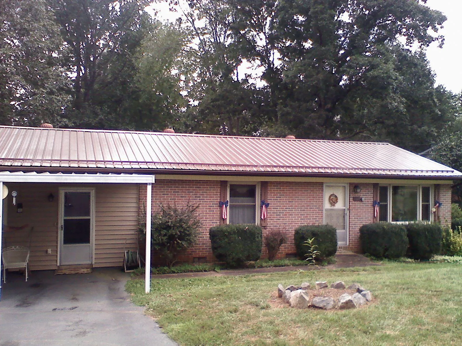 Bronze metal roof and carport on a brick ranch home in Wanaque